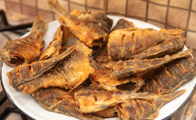Fried fish in a pan in the kitchen