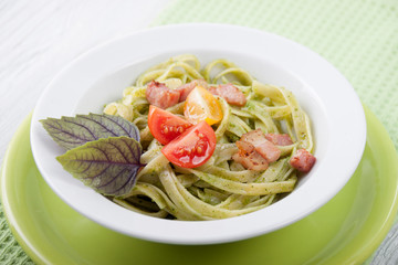 Pasta with pesto, cherry tomatoes and basil