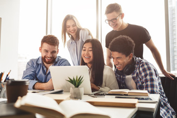 Multiracial students preparing for exams in library