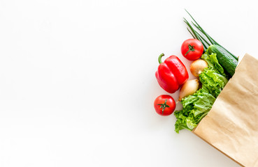 Healthy food with fresh vegetables in paper bag on white background top view space for text