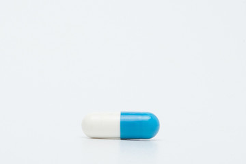 Macro view of blue capsule pill isolated over white background