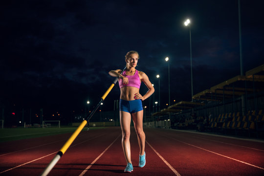 Ready to overcome difficulties. Professional female pole vaulter training at the stadium in the evening. Practicing outdoors. Concept of sport, activity, healthy lifestyle, action, movement, motion.