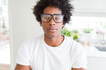 African American man wearing glasses Relaxed with serious expression on face. Simple and natural with crossed arms