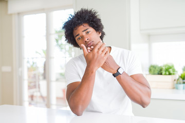 Fototapeta na wymiar Young african american man wearing casual white t-shirt sitting at home Suffering pain on hands and fingers, arthritis inflammation