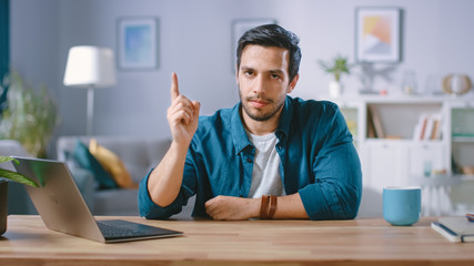 Serious Man Sitting at His Desk at Home Raises His Finger and Wags it, Warning not to Do Something...