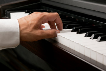 Fototapeta premium Männliche Hand spielt am Klavier
