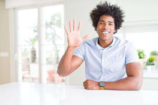 African American business man showing and pointing up with fingers number five while smiling confident and happy.