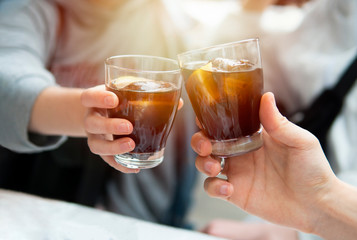 Close-up of friends clinking glasses of vermouth. Close-up of hands with glases. Friends drinking alcoholic beverage together in the cafe after work . Holidays, people, leisure and drinks concept