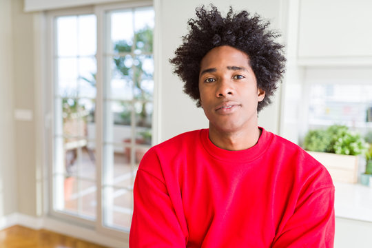 African American man wearing casual red sweatshirt Relaxed with serious expression on face. Simple and natural with crossed arms