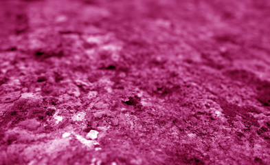 Old stone surface with blur effect in pink tone.