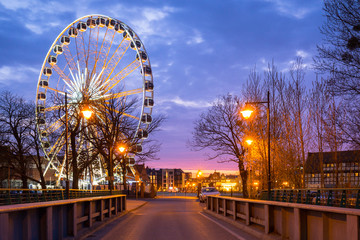 Sunset over the Gdansk city with illuminated ferris wheel, Poland
