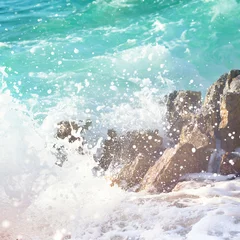 Foto op Canvas Splash of sea wave on stones. Beautiful aquamarine water. © Olga Zarytska