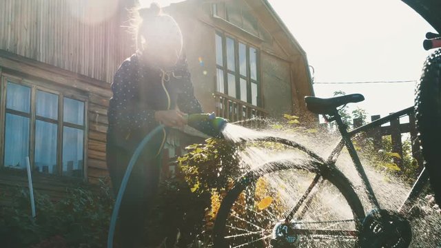 Young woman washes her bike