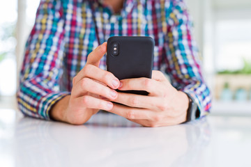 Close up of man hands using smartphone and smiling
