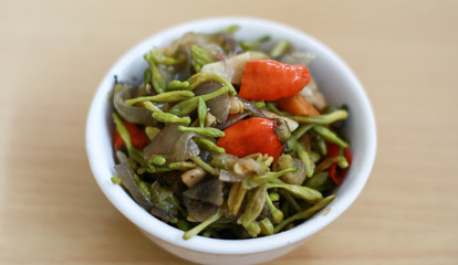 Sauteed papaya flowers on wood background.