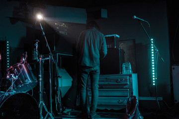 Ready to gig member of band, musician check the sound before start playing on stage in neon lights