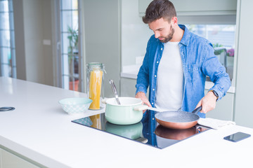 Handsome man cooking pasta at home