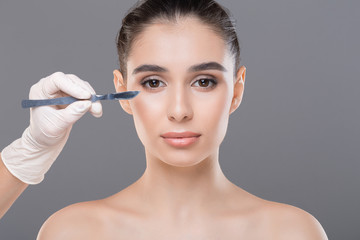 Obraz na płótnie Canvas Woman getting correction lines on face before beauty treatment