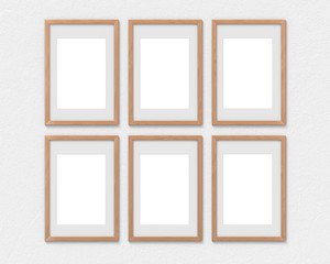 Set of 6 vertical wooden frames mockup with a border hanging on the wall. Empty base for picture or text. 3D rendering.