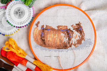 Embroidery process with mouline thread of autumn basket and an accessories for needlework. Autumn...