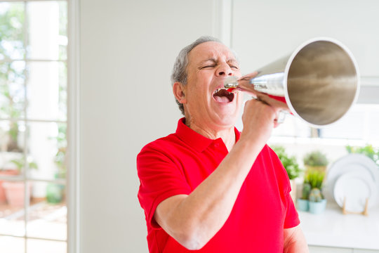 Senior man shouthing excited through vintage metal megaphone