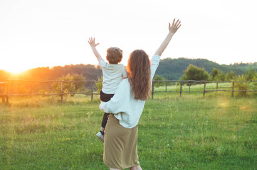 Happy mother and son on nature on sunset. Family, children and happy people concept. Mothers day