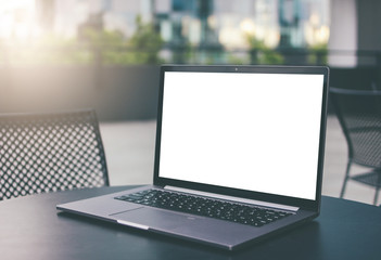 Open laptop on the table in street cafe outdoors, mock up, business, freelance concept