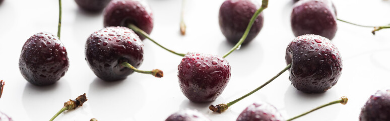 panoramic shot of fresh, sweet, red and ripe cherries covered with droplets