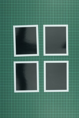 Top down view of blank photographs on cutting mat