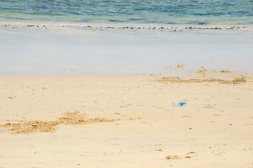 Plastic bottle garbage on the sand beach by the sea With blurred pattern background