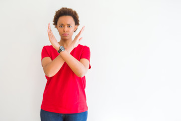 Young beautiful african american woman over white background Rejection expression crossing arms doing negative sign, angry face