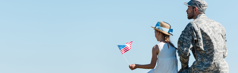 Panoramic shot of patriotic child holding American flag near veteran father - obrazy, fototapety, plakaty