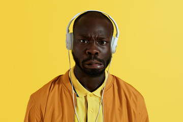 Man in white headphones listening music and making funny face