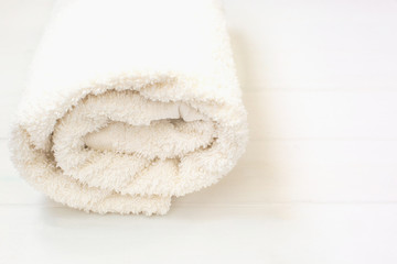 white terry towel rolled up on a white isolated background
