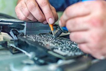 a man repairs a computer, solders a board, repairs electronics and modern technologies