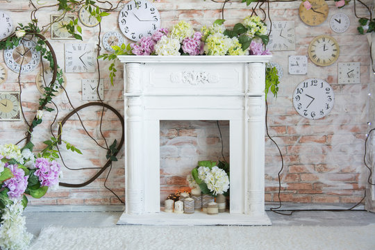 White decorative fireplace with flowers and candles.