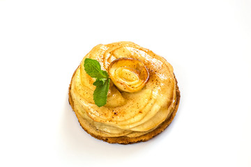 On a white plate lies a cake of apple Charlotte with mint leaves close-up on a white background...