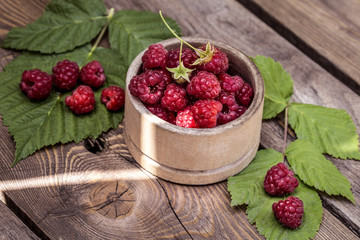fresh raspberry in wooden Cup on wooden background