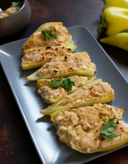 Roasted peppers stuffed with cheese and herbs on a gray plate. Characteristic dish of the Balkan cuisine. Serbian cuisine. On a dark rustic background, close-up, selective focus
