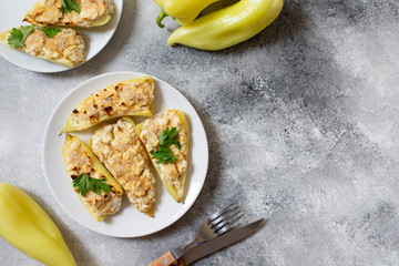 Roasted peppers stuffed with cheese and herbs on a white plate. Characteristic dish of the Balkan cuisine. Serbian cuisine. Gray background, top view, copy space