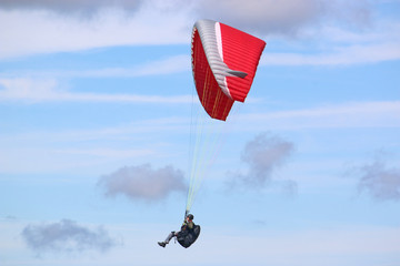 Paraglider flying red wing