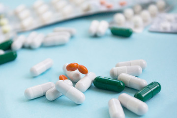 capsule pills fall on blue background copy space