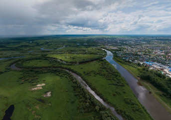 Fototapeta na wymiar Irbit city and river. Russia. Aerial. Summer, cloudy. A lots of trees and grass
