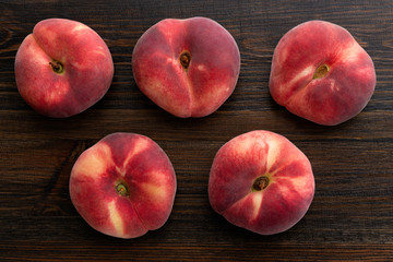 Fresh organic saturn peaches on a dark wooden table © Julia Fateyeva