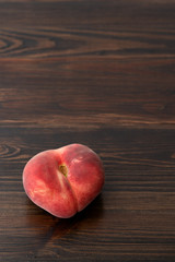 Fresh organic saturn peaches on a dark wooden table