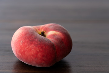 Fresh organic saturn peaches on a dark wooden table