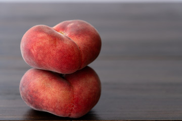 Fresh organic saturn peaches on a dark wooden table