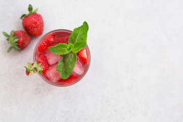 top view of the cooling summer cocktail with strawberries, ice and mint with free space for inscriptions