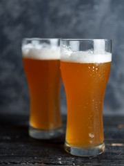 Two glasses of unfiltered cold beer on the table close-up