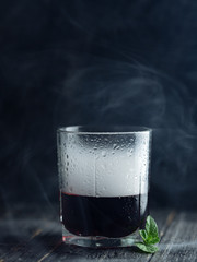 Smoke in a glass with red alcohol